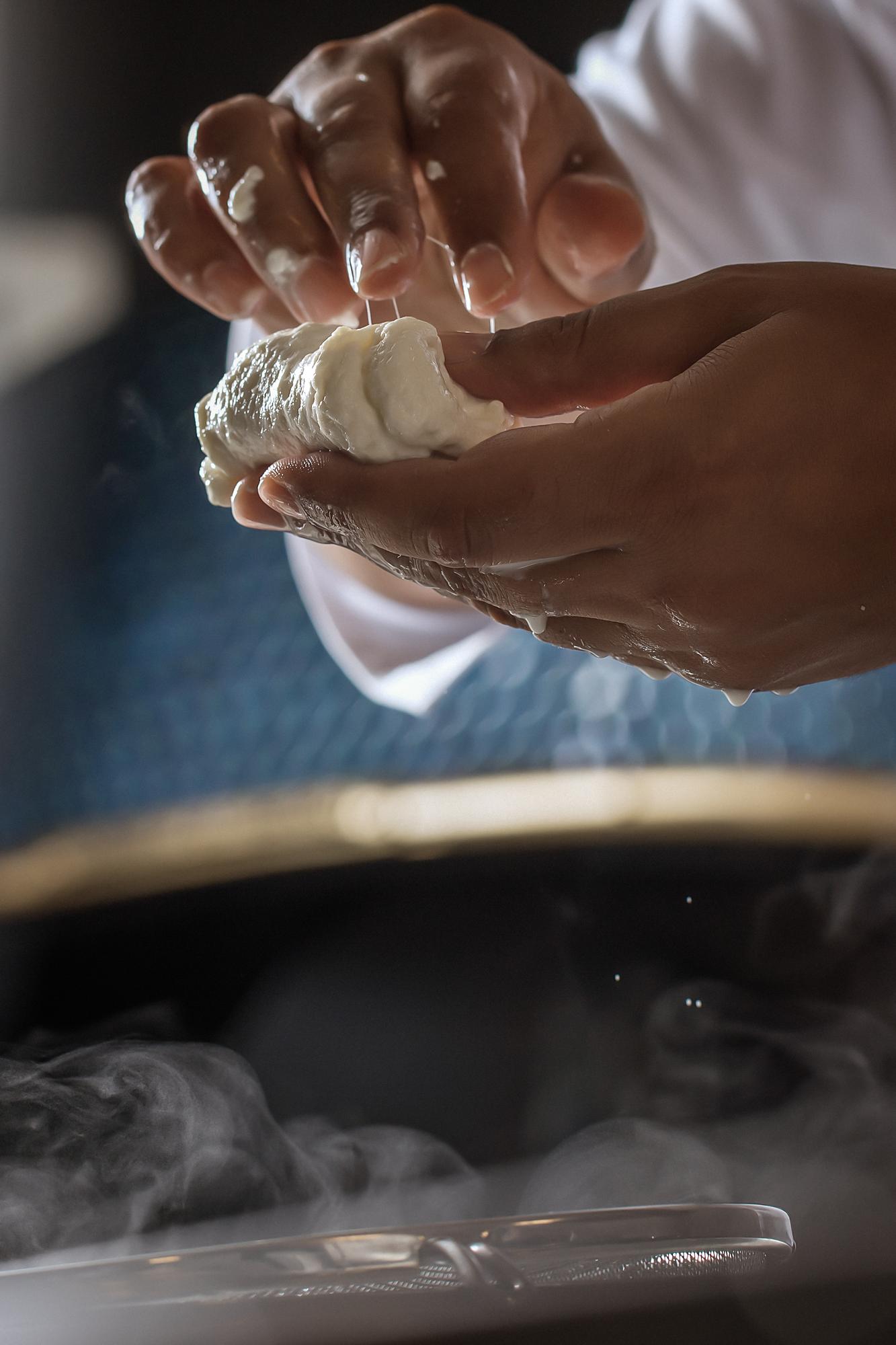 Close-up hands kneading artisan dough in warm kitchen